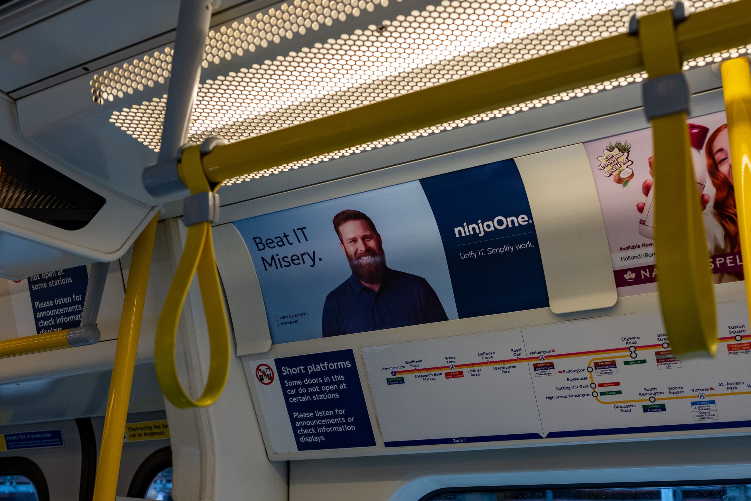 A tube car panel advertising NinjaOne above the windows of a Circle line carriage, beside the line diagram.